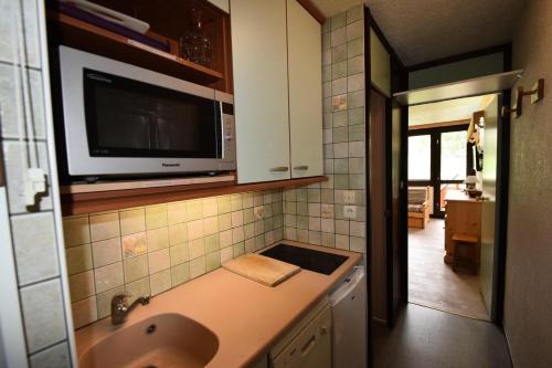 une cuisine avec un évier et un micro-ondes dans l'établissement Résidence Le France - Studio 3 pers 3 couchages LE FRANCE - PLAGNE CENTRE MAE-5084, à Aime La Plagne