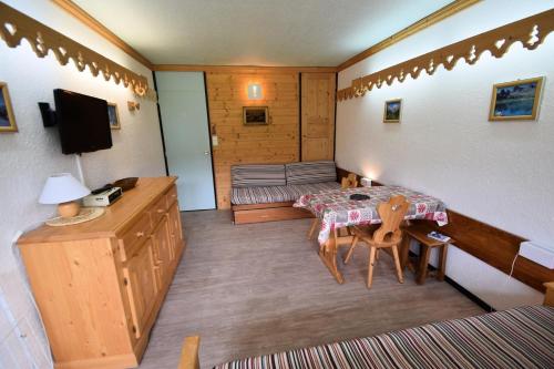 Cette petite chambre comprend une table et un canapé. dans l'établissement Résidence Le France - Studio 3 pers 3 couchages LE FRANCE - PLAGNE CENTRE MAE-5084, à Aime La Plagne