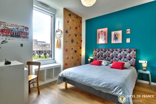 a bedroom with blue walls and a bed with red pillows at Magnifique demeure à 15 min des plages 12 adultes in Saint-Renan