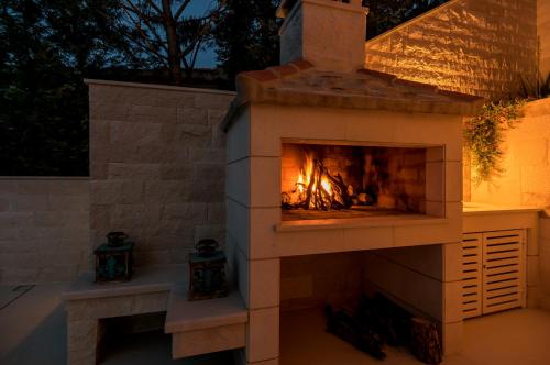 a brick fireplace with a fire in it at Villa Mila in Selca