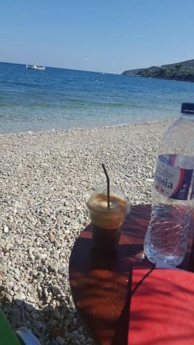 a drink and a bottle of water on a beach at Selfcatering -Studio Helen No 7 in Xiropigado