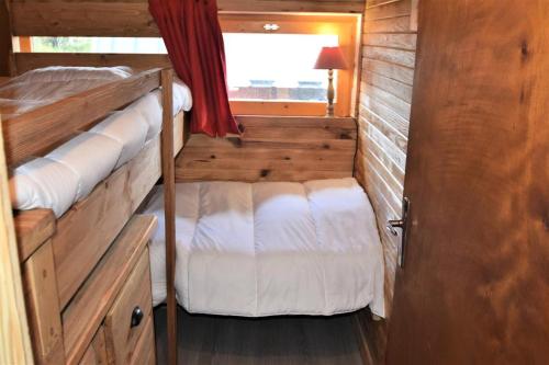 Una pequeña habitación con dos literas y una ventana. en Chalet Schi Jaacas - Chalet SCHI JAACAS - 8/10 pers - PLAGNE CENTRE MAE-8424, en Aime La Plagne