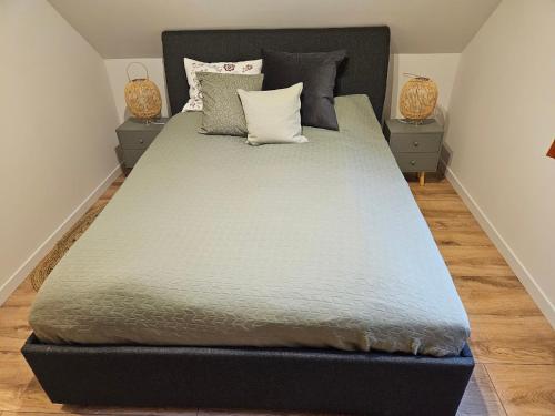 a large bed in a bedroom with two night stands at LasoNarium in Kretowiny