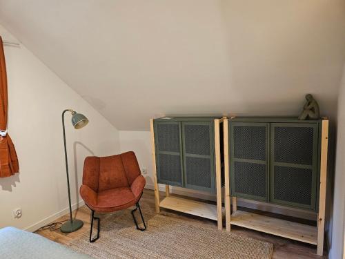 a bedroom with a chair and a cabinet at LasoNarium in Kretowiny