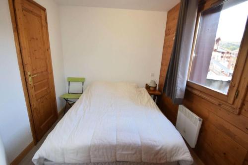 une chambre avec un lit blanc et une fenêtre dans l'établissement Résidence Lodges Des Alpages - 3 Pièces 6 pers - LES LODGES DES ALPAGES - PLAGNE SOLEIL MAE-4284, à Aime La Plagne
