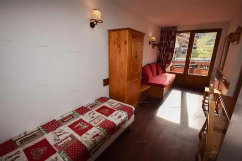 une chambre avec un lit, une chaise et une fenêtre dans l'établissement Résidence Le Cervin - 2 pièces 4 pers- WIFI- Le CERVIN- PLAGNE SOLEIL MAE-7724, à Aime La Plagne