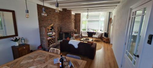 ein Wohnzimmer mit Couch und Kamin in der Unterkunft Have a nice stay! - Strand Vakantiehuis Noordwijk in Noordwijk aan Zee
