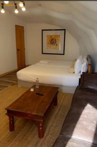 a living room with a bed and a coffee table at مزرعه ديزرت بريز راس الخيمه بها حمام سباحه وملاعب للاطفال و سينيما in Al Ḩamrānīyah