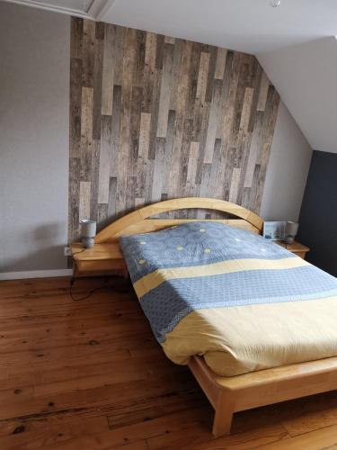- une chambre avec un lit en bois et du parquet dans l'établissement Maison au bord de la mer, à Bretteville-sur-Ay