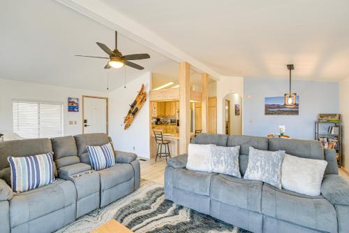 a living room with two couches and a ceiling fan at 5 Mi to River Topock Boating and Off-Roading Oasis! in Topock