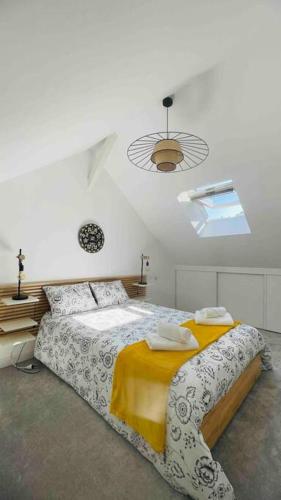 une chambre avec un grand lit avec une couverture jaune dans l'établissement Magnifique appartement dans l'hypercentre, à Nantes