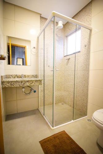 a glass shower in a bathroom with a toilet at Hotel San Rafain in Aparecida