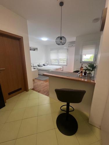 a kitchen with a bar and a stool in a room at Studio apartman - Sweet&Little in Vrbovec