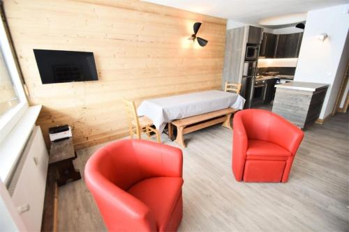 un salon avec deux chaises rouges et une table dans l'établissement Résidence Les Ecrins - 3 Pièces 6/7 pers - WIFI - LES ECRINS - PLAGNE CENTRE MAE-9314, à La Plagne Tarentaise