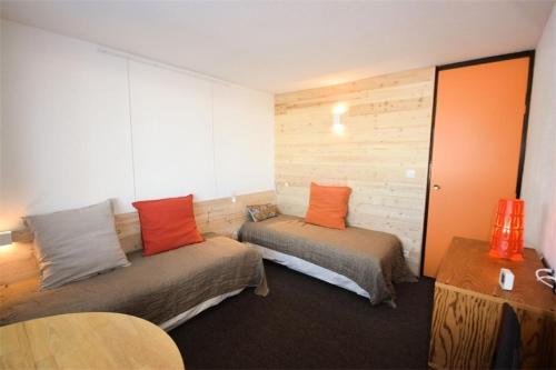 Cette chambre comprend 2 lits avec des oreillers orange. dans l'établissement Résidence Le France - Studio pour 3 Personnes 324, à Aime La Plagne