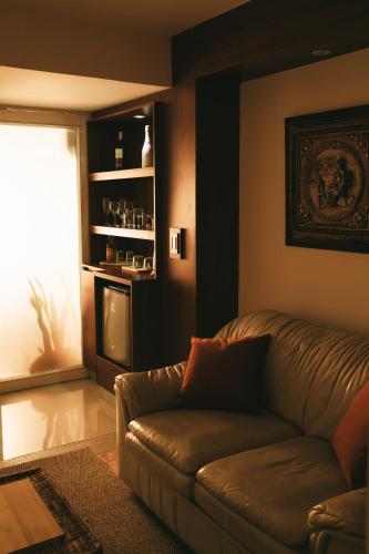 a living room with a leather couch and a television at drb Suites in Cali