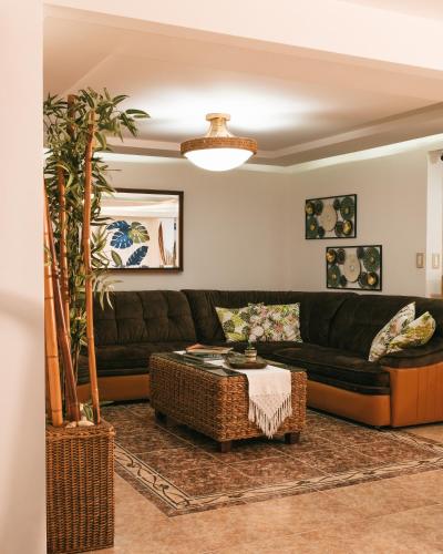 a living room with a black couch and a table at drb Suites in Cali