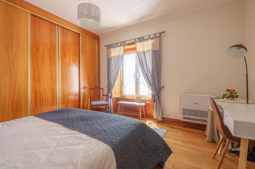 a bedroom with a bed and a desk and a window at Apartamento T1 Charme, condomínio perto de Pombal in Pombal