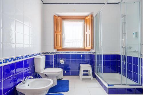 a blue and white bathroom with a toilet and a sink at Apartamento T1 Charme, condomínio perto de Pombal in Pombal