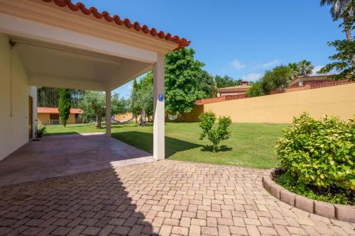 a pavilion with a brick walkway in a yard at Apartamento T1 Charme, condomínio perto de Pombal in Pombal