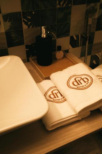 two towels sitting on a counter next to a sink at drb Suites in Cali