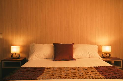 a bedroom with a bed with two lamps on both sides at drb Suites in Cali