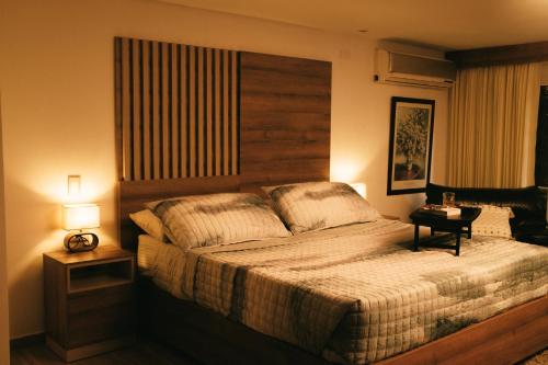 a bedroom with a large bed with a wooden headboard at drb Suites in Cali