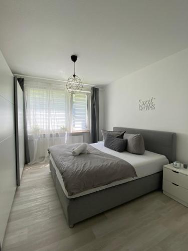 a bedroom with a large bed and a chandelier at Seli Apartment in Bremerhaven