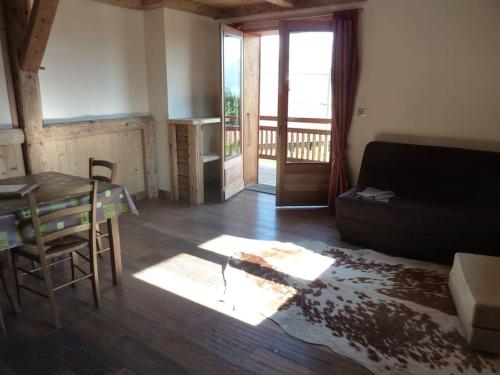 un salon avec une table et un canapé dans l'établissement Premier étage d'une ferme rénovée, à Passy