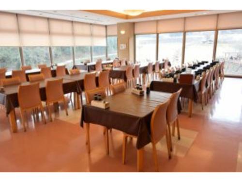 a dining room with tables and chairs and windows at Sunroad Kibiji - Vacation STAY 06006v in Soja