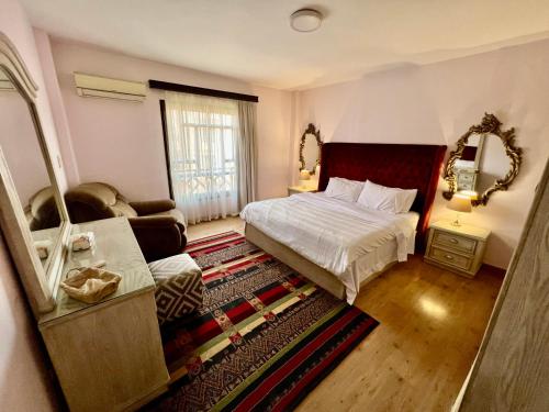 Un dormitorio con una cama, un sofá y un espejo. en Luxurious 3 BR Rustic Apartment Overlooking Huge Garden - For Families and Couples, en El Cairo