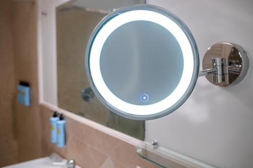 a mirror on the wall of a bathroom at Palazzo Alfeo Aparthotel in Siracusa