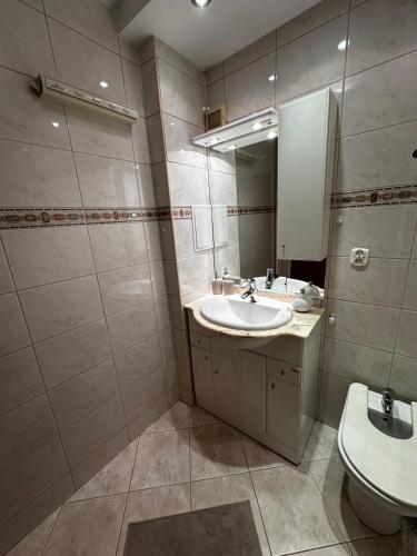 a bathroom with a sink and a toilet and a mirror at Apartament Gdynia Centrum in Gdynia