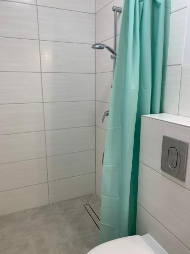 a bathroom with a shower with a blue shower curtain at Albatrosa 17 - apartament nr 3 in Rewal
