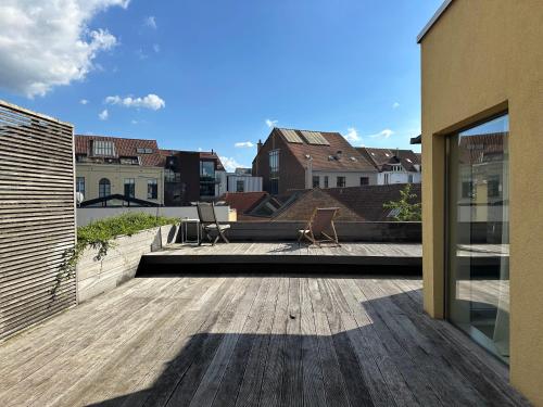 a wooden deck with two chairs on top of a building at Down Town Penthouse with Private Parking in Brussels