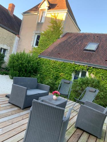 d'une terrasse avec des chaises en osier, une table et des chaises. dans l'établissement Les chambres perchées de Boece, à Boëcé