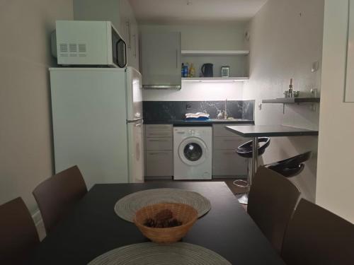 Il comprend une petite cuisine avec une table et un réfrigérateur blanc. dans l'établissement Proche Disneyland Paris - Appartement avec balcon sans vis a vis - parking prive Résidence calme, à Montévrain