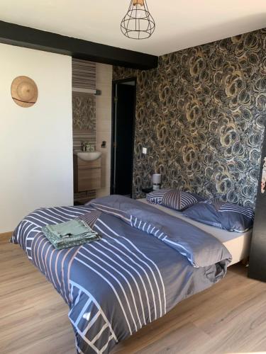 une chambre avec un grand lit avec des draps bleus dans l'établissement Les chambres perchées de Boece, à Boëcé