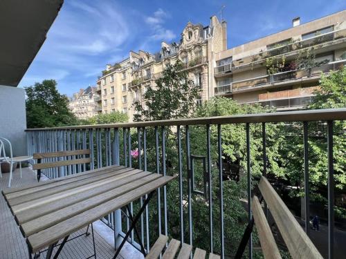 - un balcon avec un banc en bois et un bâtiment dans l'établissement Parisian Charm Close Trocadero, à Paris