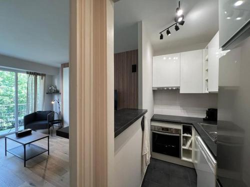 une cuisine avec des armoires blanches et un comptoir noir dans l'établissement Parisian Charm Close Trocadero, à Paris