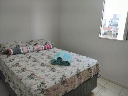 a bed with a pair of shoes sitting on it at Apto no Bairro Alto Umuarama in Uberlândia
