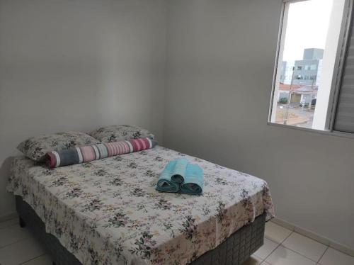 a bedroom with a bed with a pair of goggles on it at Apto no Bairro Alto Umuarama in Uberlândia