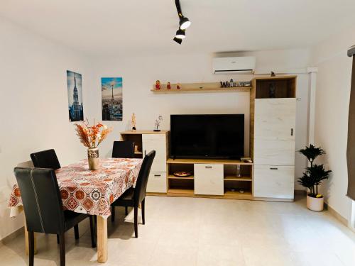 a dining room with a table with chairs and a television at Apartamento en Torre del Mar in Torre del Mar