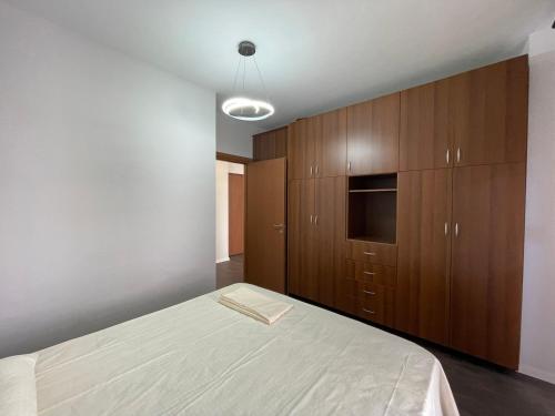 a bedroom with a bed and wooden cabinets at JO-AL, Delijorgji in Tirana