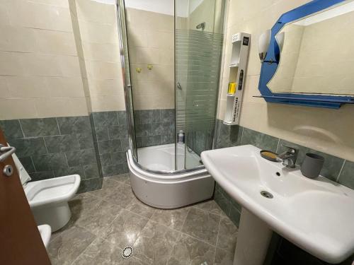 a bathroom with a sink and a shower and a toilet at JO-AL, Delijorgji in Tirana