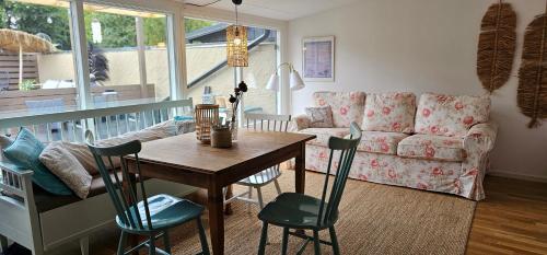 ein Wohnzimmer mit Tisch und Couch in der Unterkunft Real holiday feeling next to beach and restaurant in Beddinge Strand