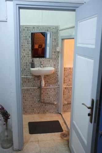 a bathroom with a sink and a mirror at Belle maison dans la Médina in Tunis