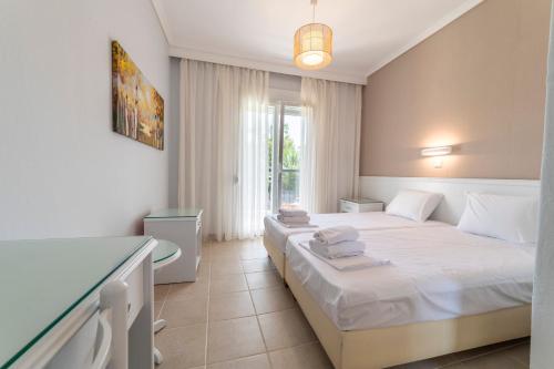 a hotel room with two beds and a bathroom at Theramvos Superior Apartments in Hanioti