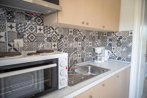 a kitchen with a sink and a stove at Theramvos Superior Apartments in Hanioti