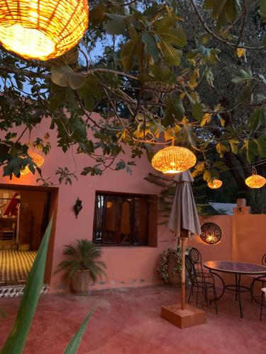 a patio with a table and chairs under a tree at Auberge Le Mouflon in Ouirgane